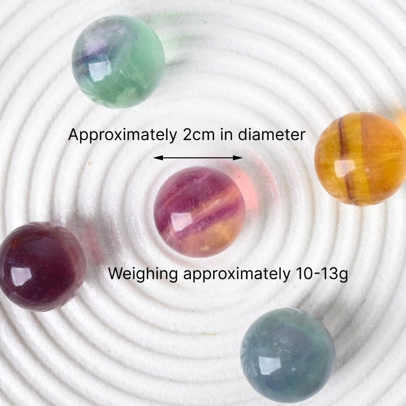 Natural 20mm rainbow fluorite crystal sphere with polished green and purple gemstone patterns