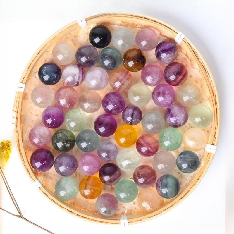 Natural 20mm rainbow fluorite crystal sphere with polished green and purple gemstone patterns