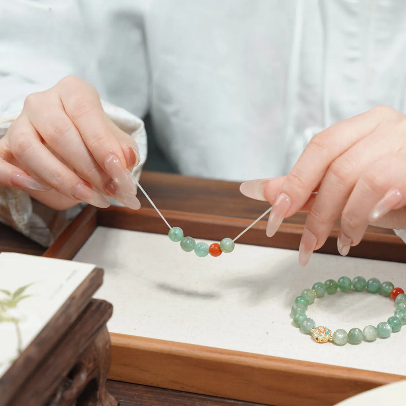 WhisperCrystal™ Natural Green Aventurine and Red Agate Bracelet featuring polished 8mm green aventurine beads, a vibrant red agate accent, and an elegant enamel-inspired charm in a Dunhuang-inspired color palette.